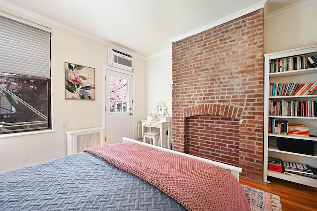 bedroom with wood finished floors, crown molding, and an AC wall unit