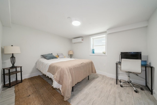 bedroom featuring a wall unit AC and light hardwood / wood-style floors