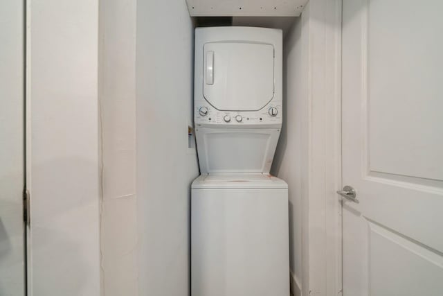 clothes washing area with stacked washer and clothes dryer