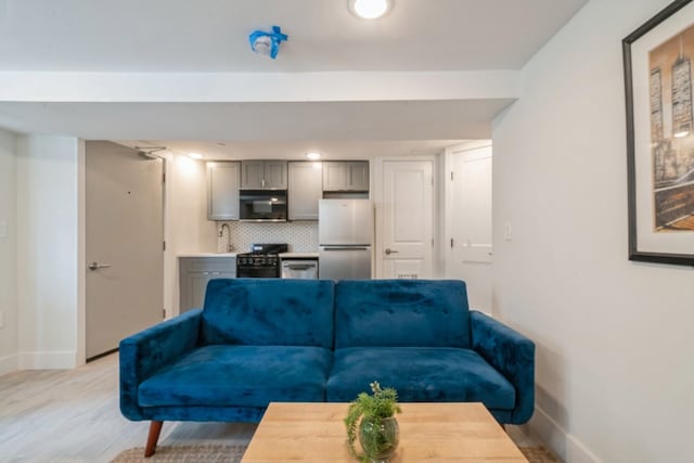 living room featuring light wood-type flooring and sink