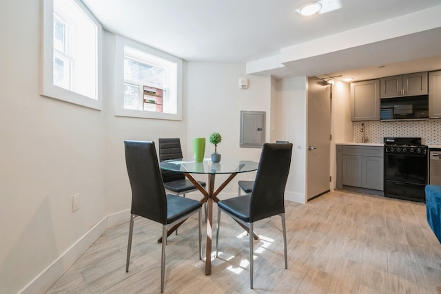 dining area featuring electric panel and light hardwood / wood-style flooring