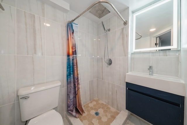 bathroom with tile walls, vanity, toilet, and curtained shower