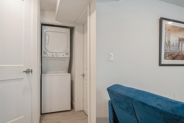 clothes washing area with stacked washer / drying machine and light hardwood / wood-style floors