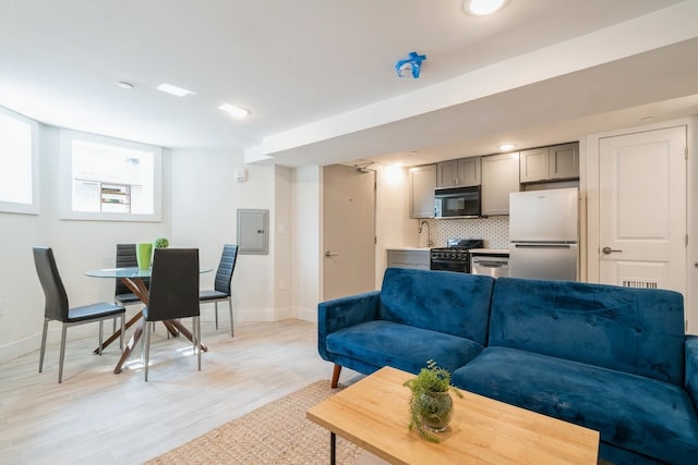 living room with electric panel and light hardwood / wood-style flooring