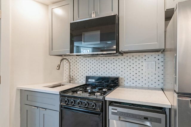 kitchen featuring decorative backsplash, black appliances, sink, and gray cabinetry