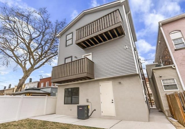 285 Lembeck Ave Unit 1, Jersey City, NJ 07305 - rear view of house with fence, a patio area, a balcony, stucco siding, and cooling unit