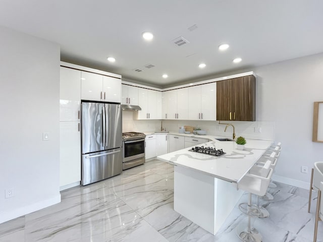 285 Lembeck Ave Unit 1, Jersey City, NJ 07305 - kitchen with a peninsula, a sink, stainless steel appliances, visible vents, and light countertops