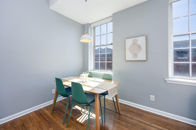 dining space featuring baseboards and wood finished floors