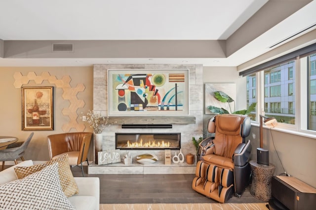 living room with hardwood / wood-style flooring and a premium fireplace