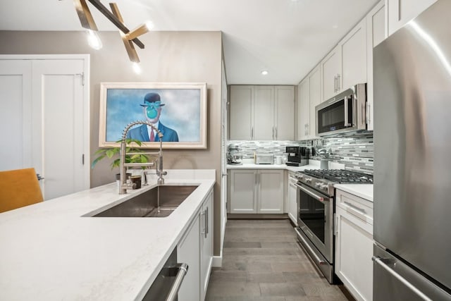 kitchen featuring dark wood-type flooring, sink, decorative backsplash, white cabinetry, and stainless steel appliances