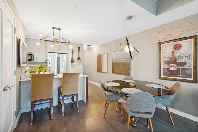 dining space featuring dark hardwood / wood-style flooring and an inviting chandelier