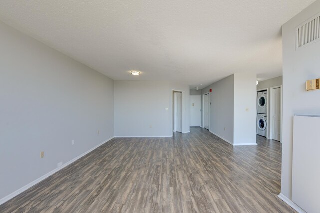 1011 Harmon Cv Unit 1011, Secaucus, NJ 07094 - unfurnished room featuring estacked washer and dryer, dark wood-style flooring, and baseboards