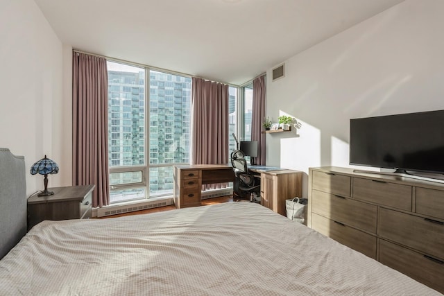 bedroom with hardwood / wood-style flooring and a wall of windows