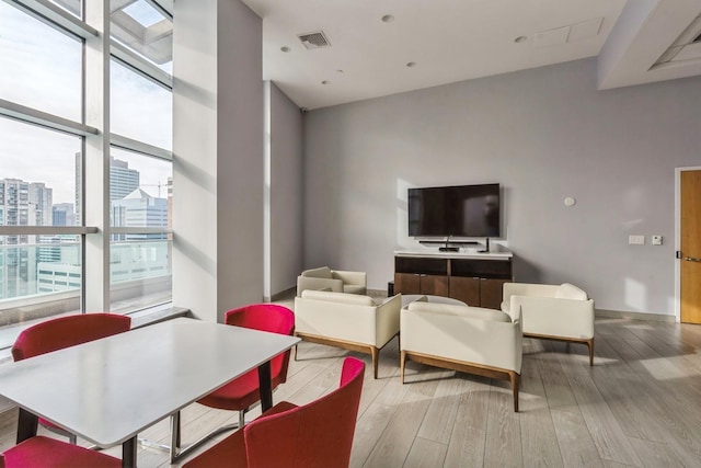 living room featuring a wall of windows and light wood-type flooring