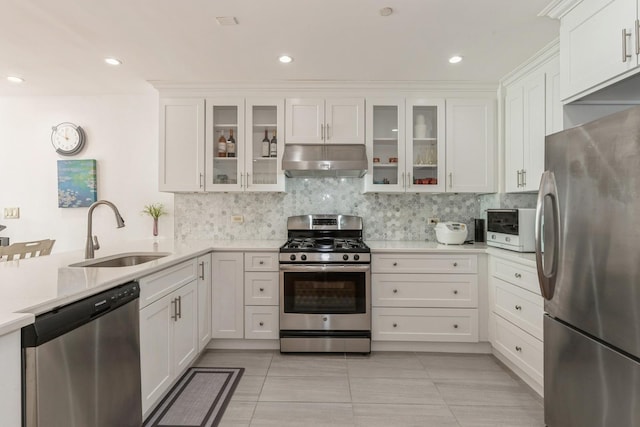 kitchen with light tile patterned flooring, sink, white cabinetry, stainless steel appliances, and decorative backsplash