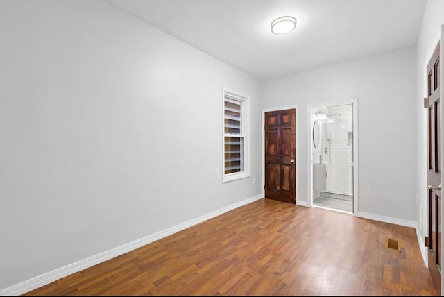 interior space with visible vents, built in shelves, baseboards, and wood finished floors