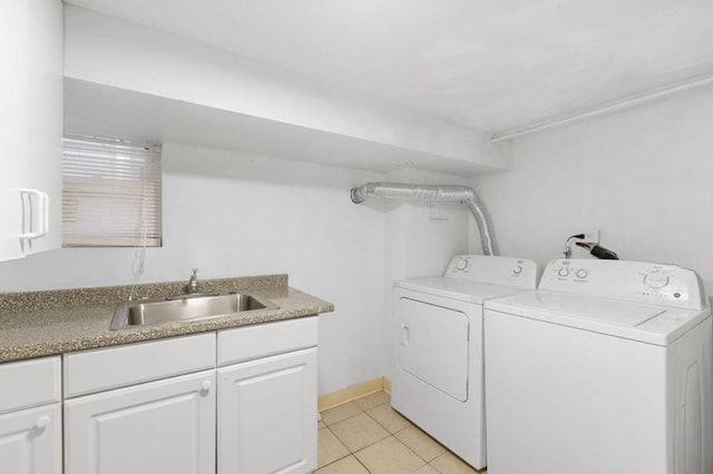 laundry room featuring washing machine and dryer, cabinet space, a sink, and light tile patterned floors