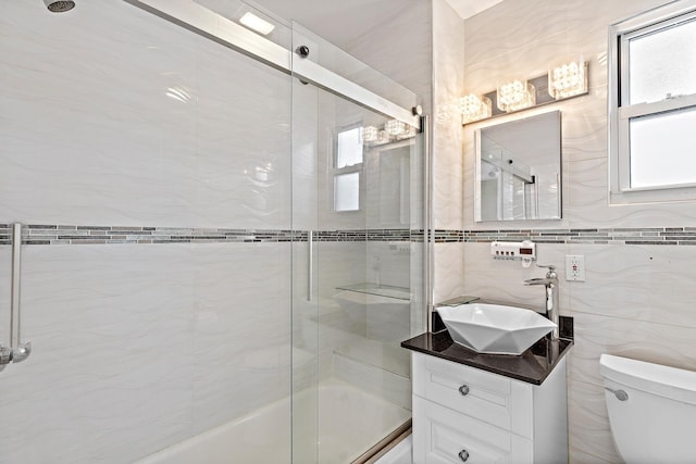 full bath featuring toilet, a healthy amount of sunlight, bath / shower combo with glass door, and vanity