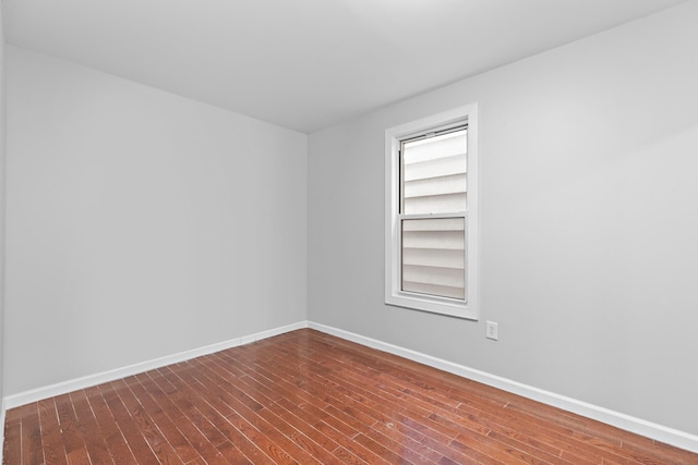 spare room with dark wood-type flooring and baseboards