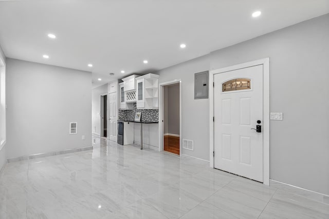 unfurnished living room featuring electric panel, visible vents, and recessed lighting