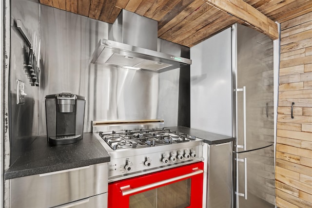 205 10th St Unit 3G, Jersey City, NJ 07302 - kitchen featuring wall chimney range hood, stainless steel appliances, wooden ceiling, wooden walls, and dark countertops