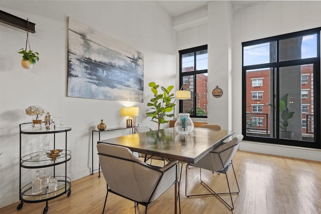 205 10th St Unit 3G, Jersey City, NJ 07302 - dining room featuring light wood-type flooring and a towering ceiling