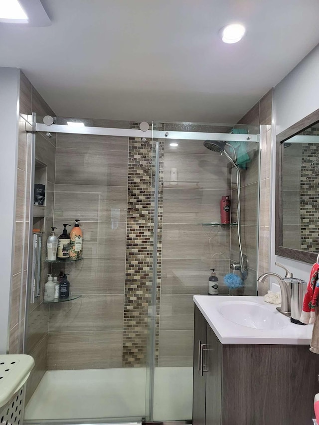 bathroom featuring vanity and a shower with door