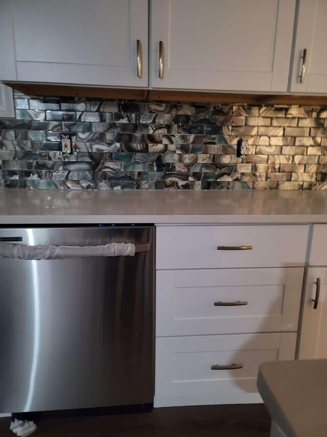 kitchen with backsplash, white cabinetry, and stainless steel dishwasher