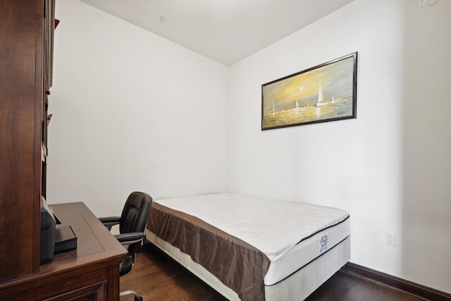 bedroom with dark wood-type flooring
