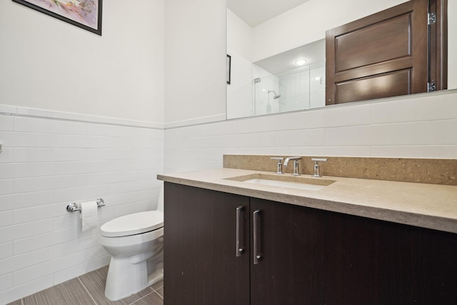bathroom featuring walk in shower, toilet, tile walls, vanity, and tile patterned flooring