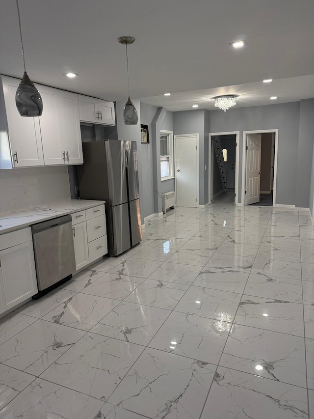 kitchen with tasteful backsplash, pendant lighting, white cabinets, and stainless steel appliances