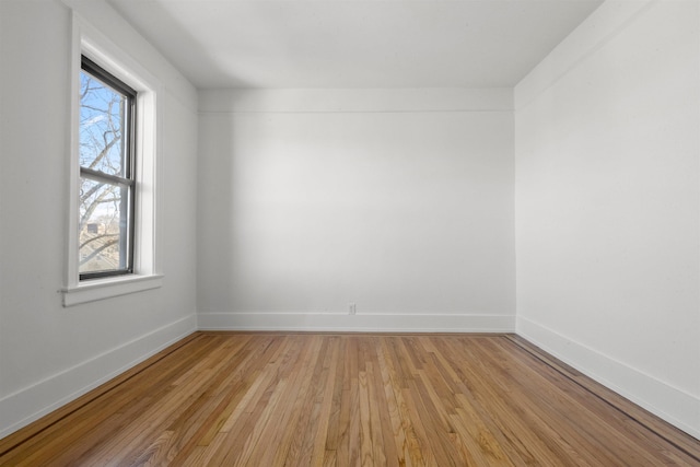 unfurnished room featuring baseboards and light wood finished floors