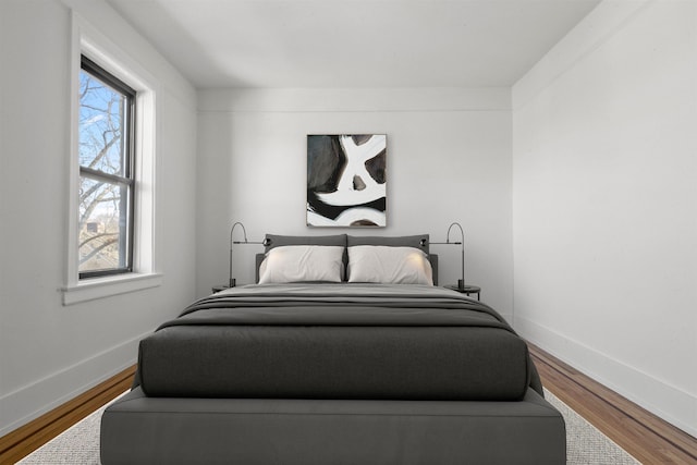 bedroom featuring baseboards and wood finished floors