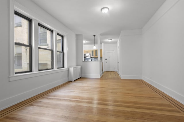 unfurnished room featuring baseboards and light wood finished floors