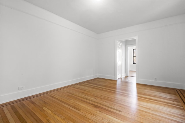 unfurnished room with light wood-style flooring and baseboards