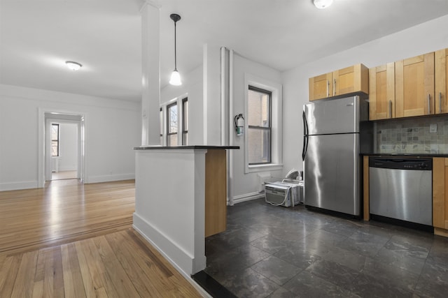 kitchen with dark countertops, tasteful backsplash, baseboards, and stainless steel appliances