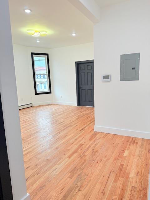 530 45th St, Union City, NJ 07087 - spare room with electric panel, a baseboard radiator, light wood finished floors, and recessed lighting