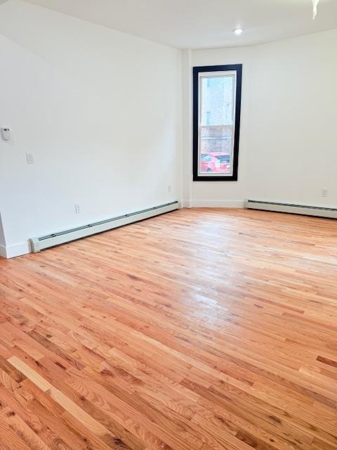 530 45th St, Union City, NJ 07087 - empty room with a baseboard radiator, light wood finished floors, and recessed lighting