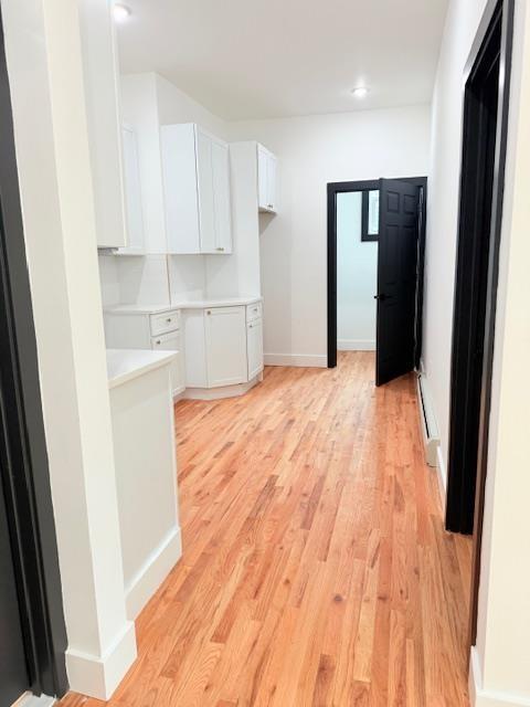 530 45th St, Union City, NJ 07087 - hall with light wood-style floors, a baseboard heating unit, and recessed lighting