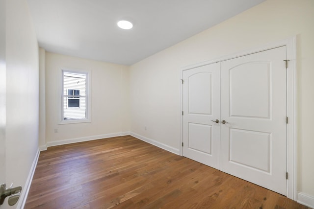 empty room with baseboards and wood finished floors