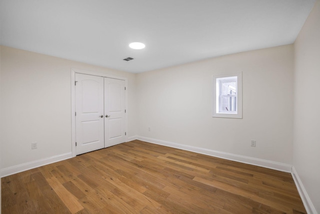 empty room with visible vents, baseboards, and wood finished floors