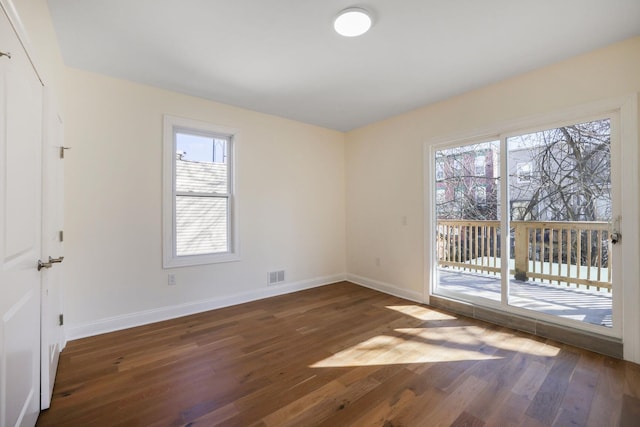 unfurnished room with visible vents, baseboards, and wood finished floors