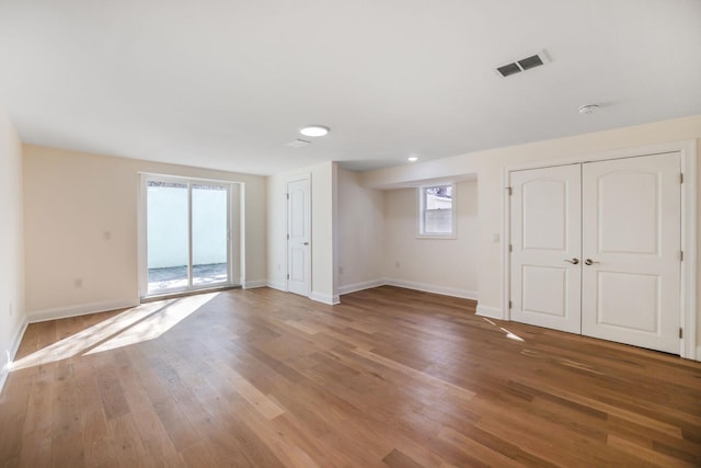 empty room featuring light wood-type flooring, visible vents, and baseboards