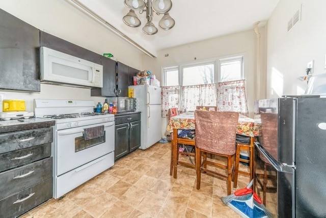 kitchen with white appliances and a chandelier