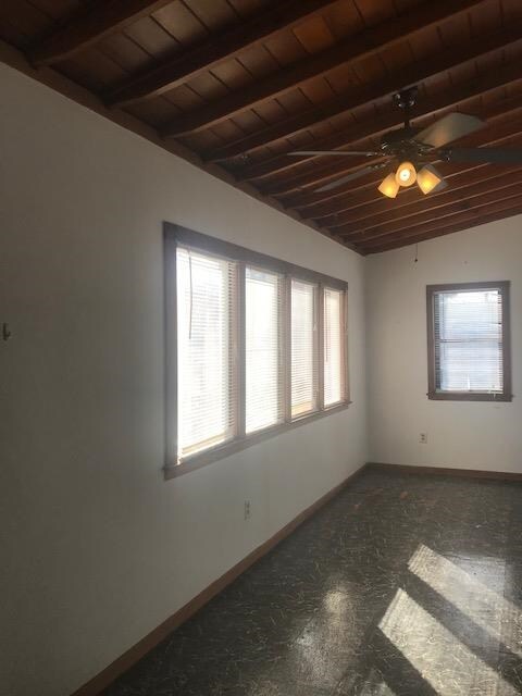 unfurnished room featuring ceiling fan, wood ceiling, and vaulted ceiling with beams