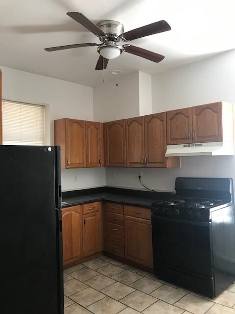 kitchen with black appliances, ceiling fan, and light tile patterned flooring