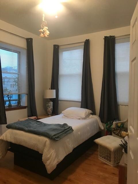 bedroom with hardwood / wood-style flooring and an inviting chandelier