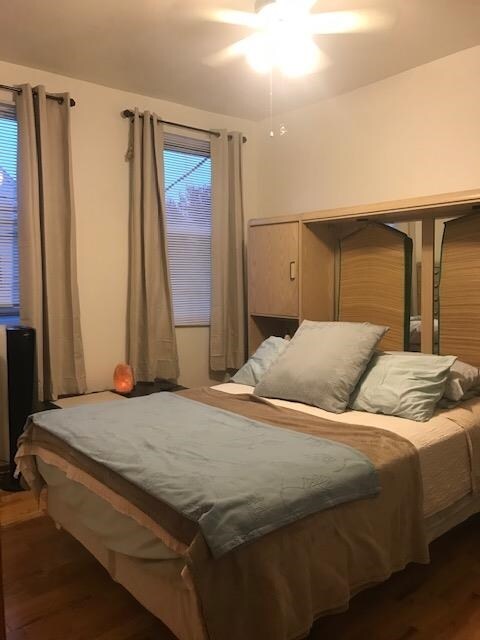 bedroom with dark wood-type flooring and ceiling fan