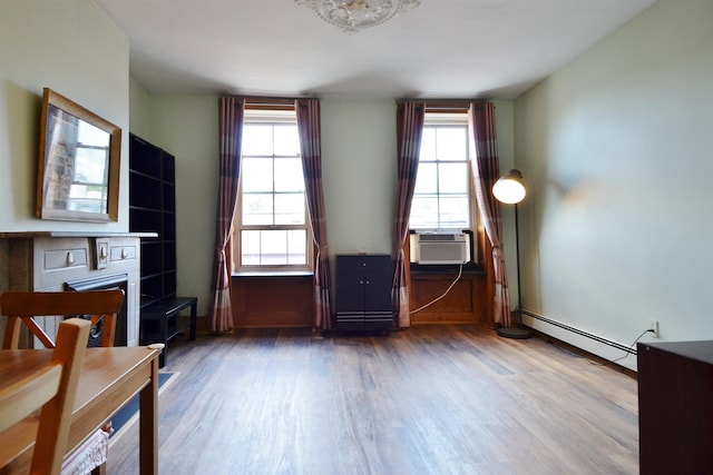 interior space with hardwood / wood-style floors, plenty of natural light, cooling unit, and baseboard heating