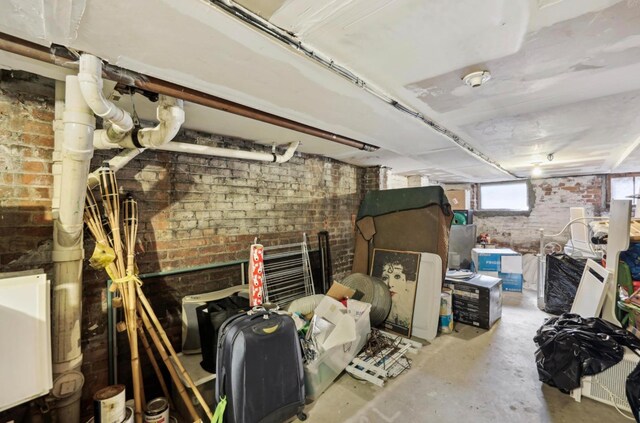 basement featuring brick wall